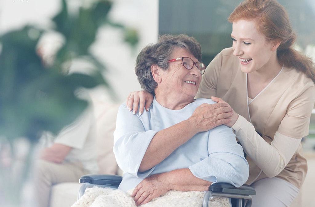 anziana sorridente accudita da un'infermiera, rsa e senior hosuing
